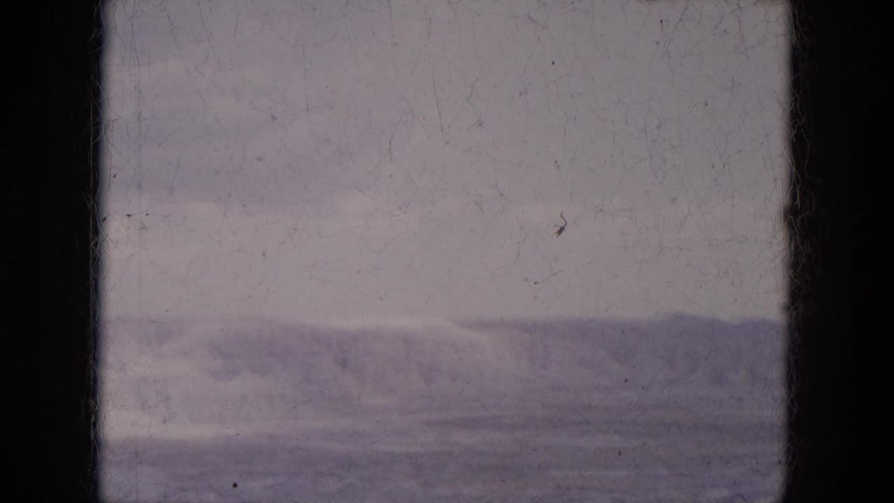 1969 Lake Canyon, Arizona travel footage showing a distant ridge under gray sky, partially blocked by the vehicle window structure.