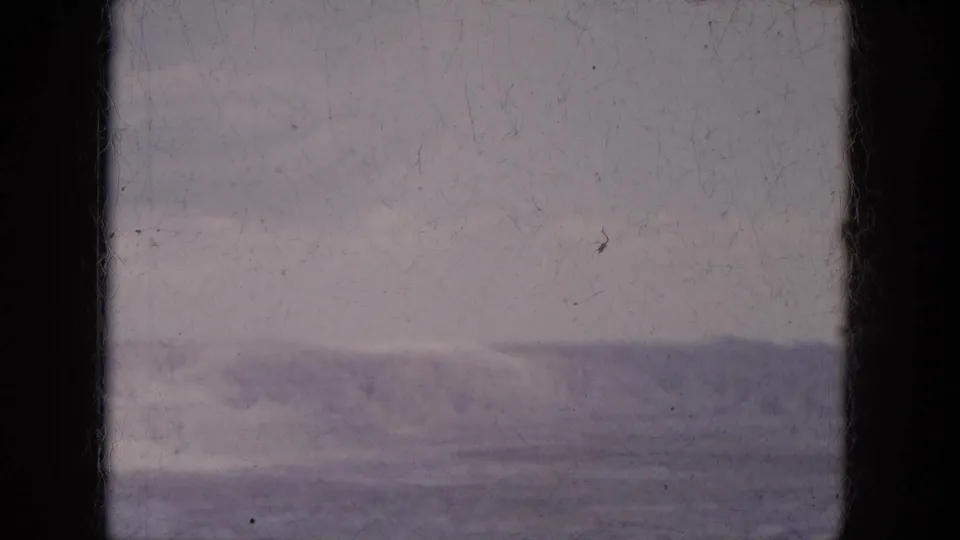 1969 Lake Canyon, Arizona travel footage showing a distant ridge under gray sky, partially blocked by the vehicle window structure.
