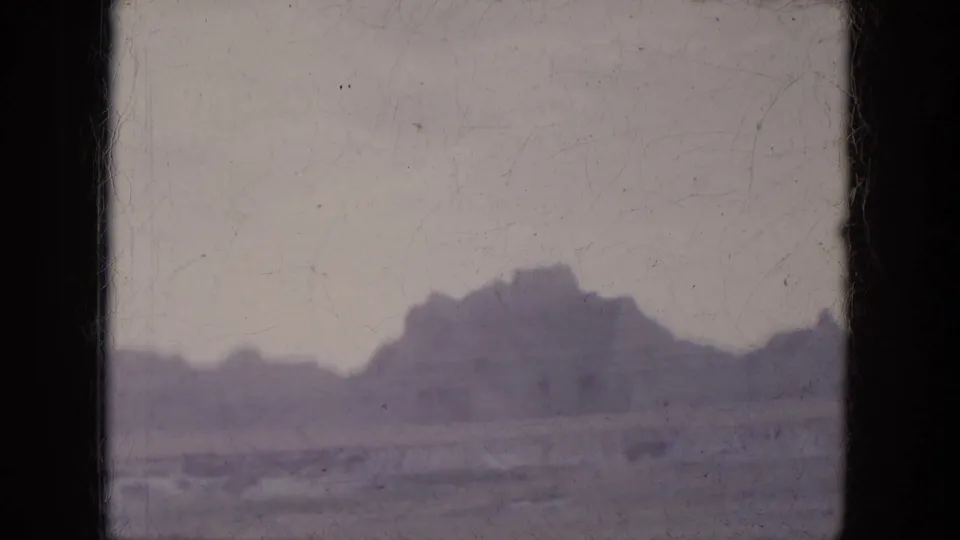 1969 8mm view through a car window toward purple-gray desert hills near Lake Canyon, Arizona.