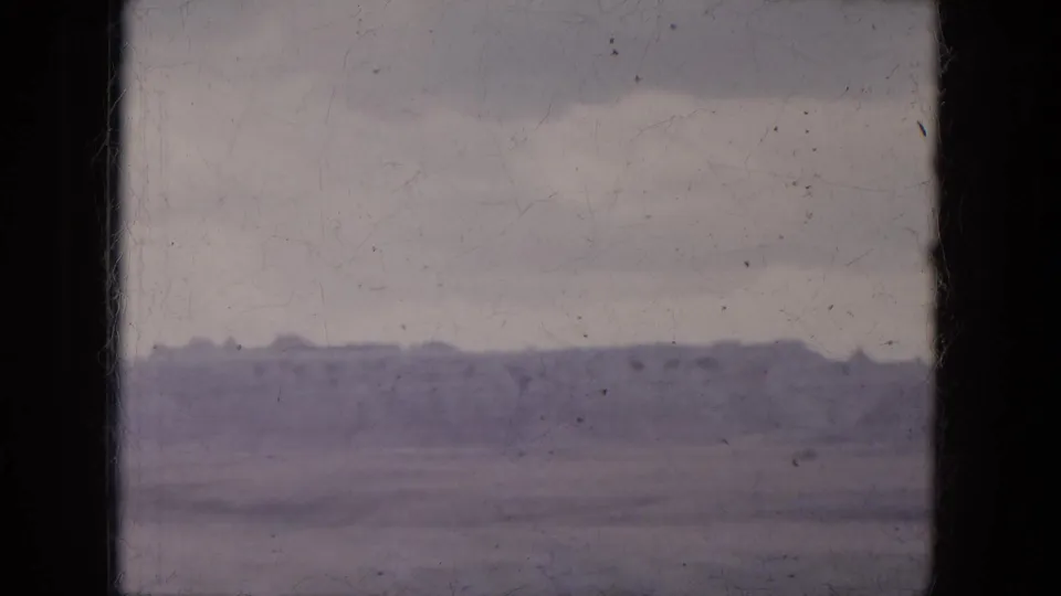 Aged 8mm view of a distant ridge and empty desert flats, likely filmed near Lake Canyon, Arizona in 1969.