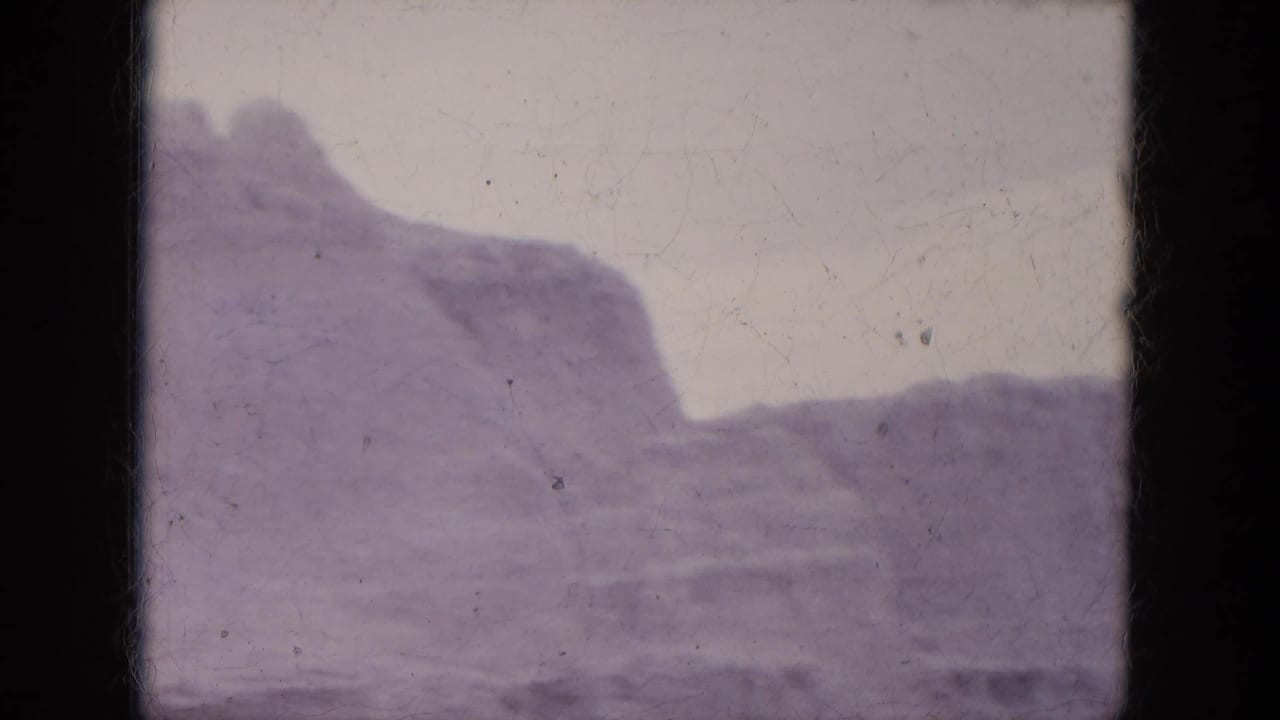 1969 Lake Canyon, Arizona footage showing a rugged canyon wall with exposed layers and a broad desert slope in front.