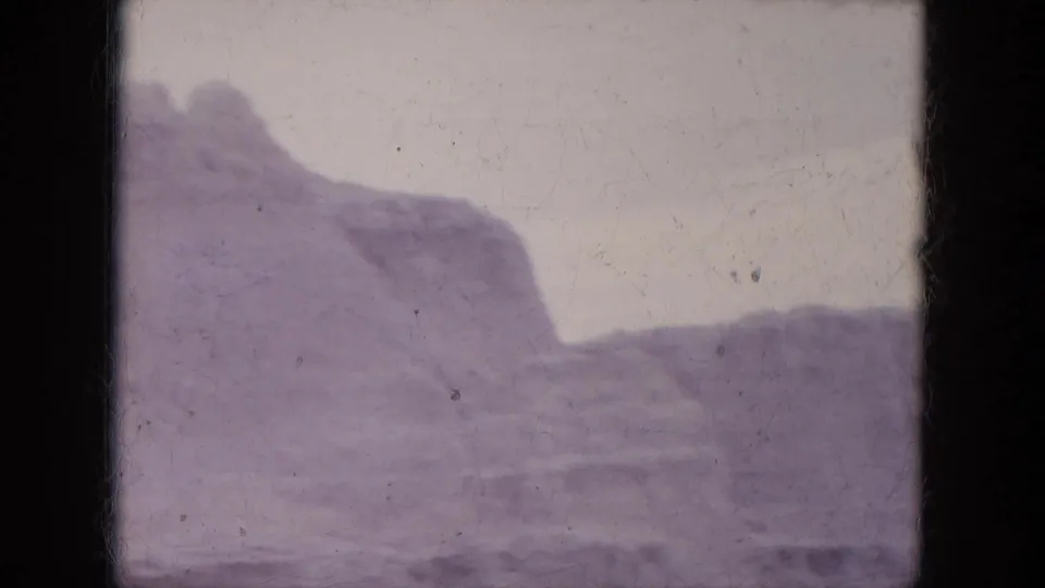 1969 Lake Canyon, Arizona footage showing a rugged canyon wall with exposed layers and a broad desert slope in front.