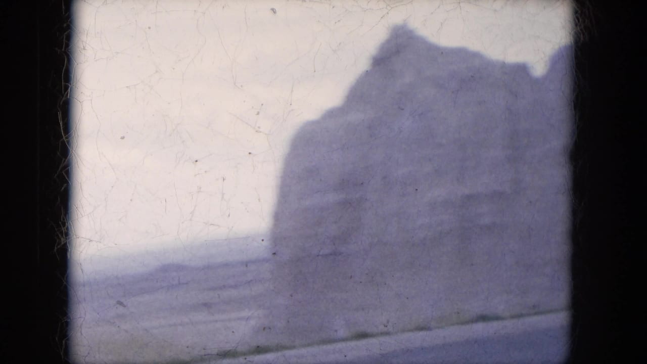 Large desert rock formation seen through dark film-frame borders.