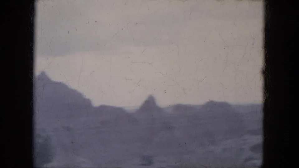 1969 8mm Lake Canyon, Arizona road-trip frame showing a rocky desert skyline with low ridges and butte-like formations.