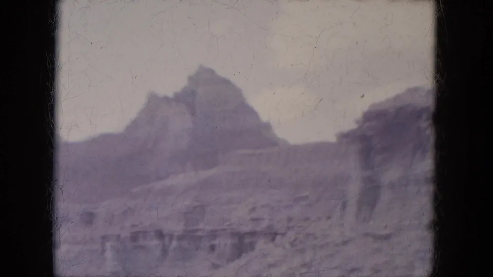 8mm frame from the 1969 Lake Canyon, Arizona trip showing a rocky slope and pointed ridge in purple-tinted color.