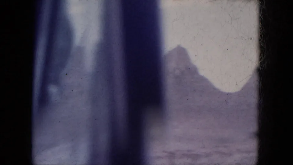 1969 Arizona 8mm travel frame with a blurred vehicle or window edge beside a distant canyon formation.
