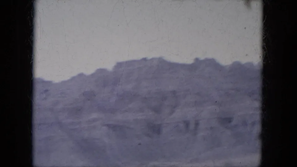 1969 8mm view across layered Lake Canyon, Arizona rock formations with a soft blue-purple film cast.