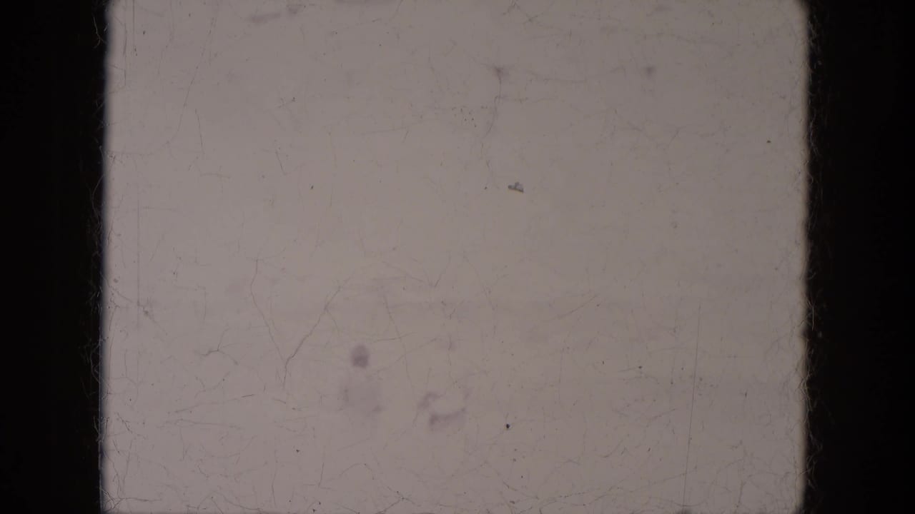 Soft, scratched 8mm frame from Lake Canyon, Arizona, with a faint person crossing the open area.
