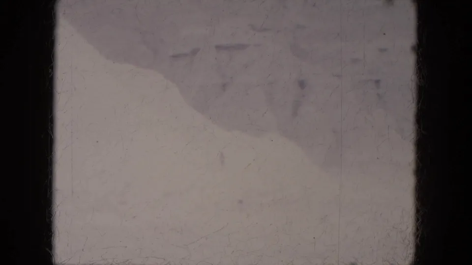 1969 Lake Canyon, Arizona 8mm frame showing pale snow-covered ground with raised mounds and visible film wear.