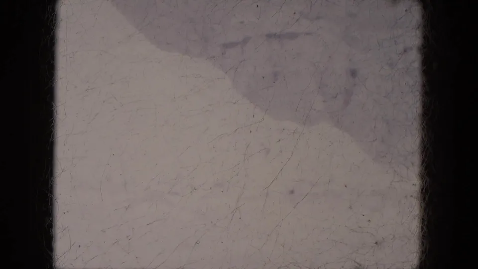 1969 Lake Canyon, Arizona 8mm still with snow-covered terrain, a broad diagonal mound, and visible dust and scratches.
