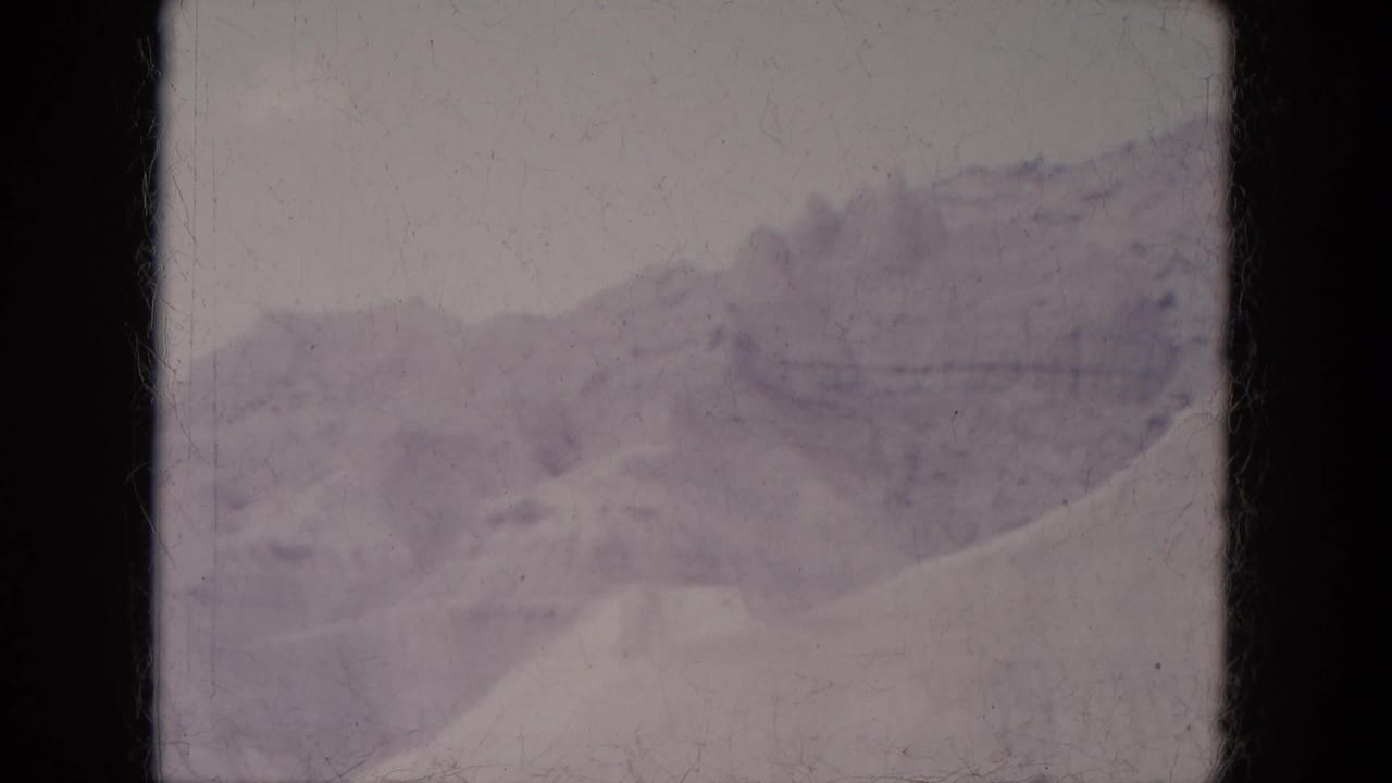 Vintage 8mm view of snow-covered hills and a distant ridge in the Lake Canyon, Arizona landscape.