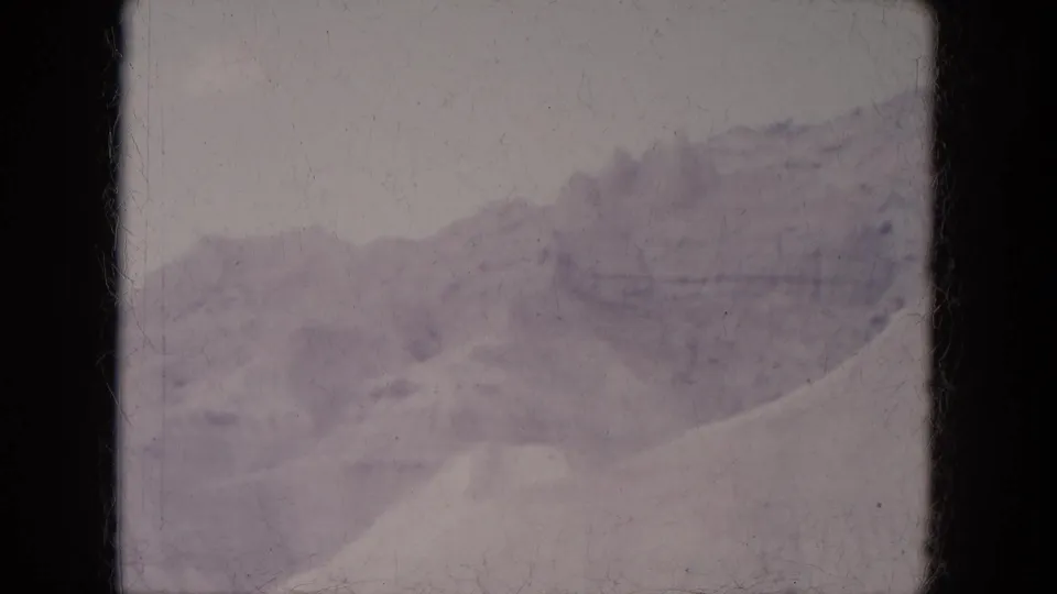 Vintage 8mm view of snow-covered hills and a distant ridge in the Lake Canyon, Arizona landscape.