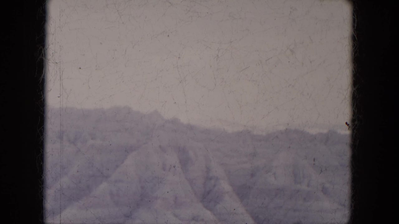 1969 Lake Canyon, Arizona view of layered canyon hills, muted by faded 8mm color and framed by black gate edges.
