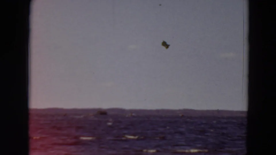 1969 Minnesota 8mm frame showing rough open water, faint whitecaps, a low horizon, and dark film-gate edges.