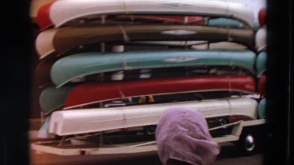 Minnesota 1969 frame showing stacked canoes and the back of a partially visible person near the bottom edge.
