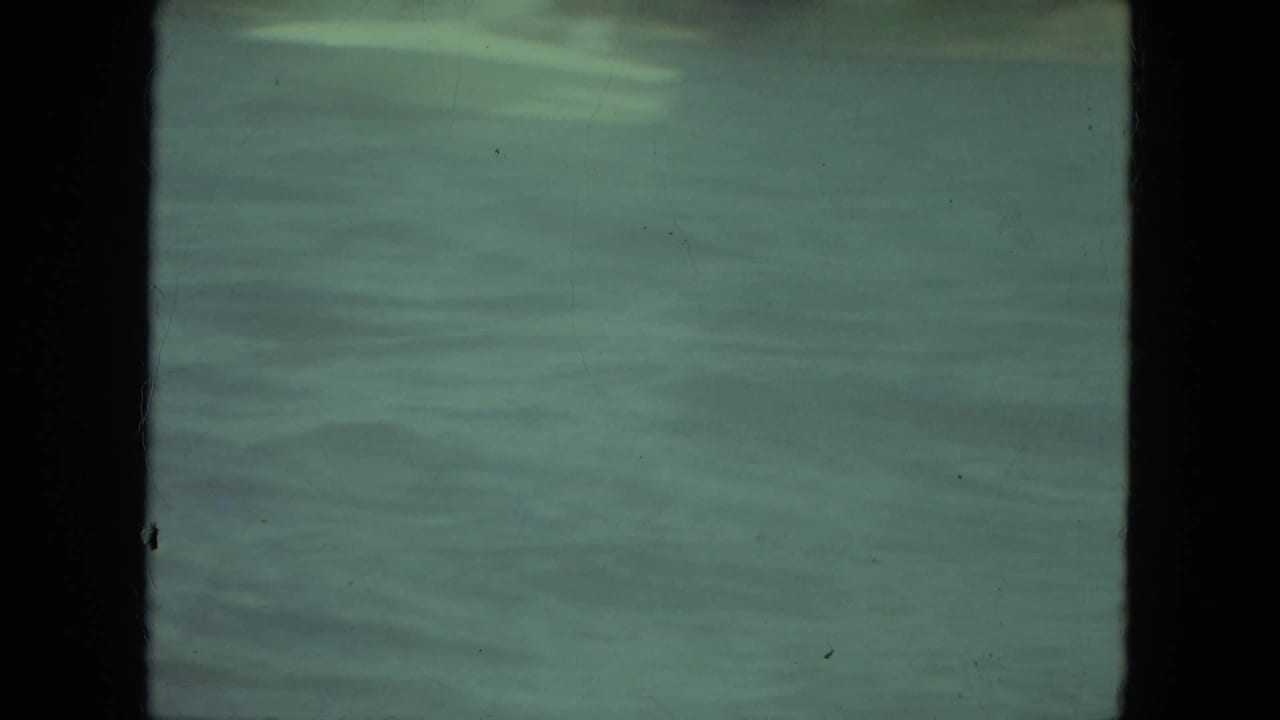 Soft 1971 Mississippi lake view with rippled water and a faint distant shoreline, with no clear foreground subject in this frame.