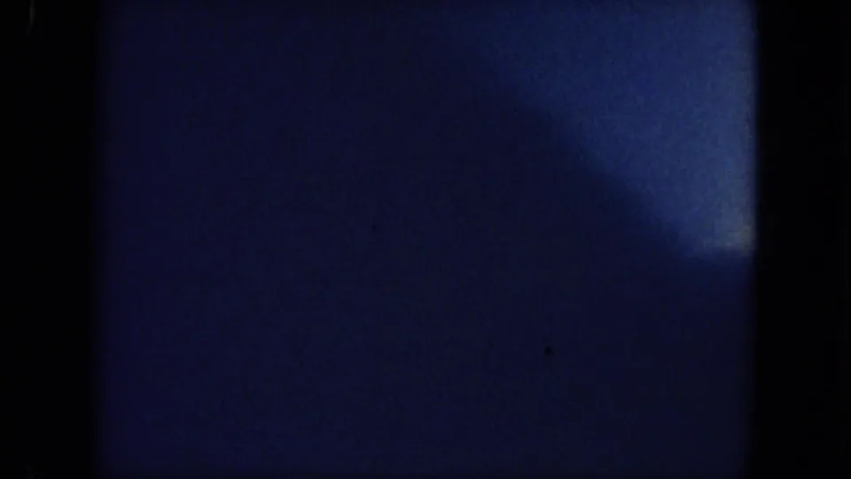 Abrupt dark, blue-toned 8mm end frame from the Mississippi boating clip, with grain and indistinct shapes.