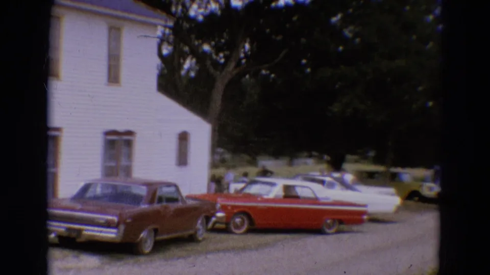 The final frame shows multiple classic cars beside the white house, including a maroon sedan and red convertible in a shaded lot.