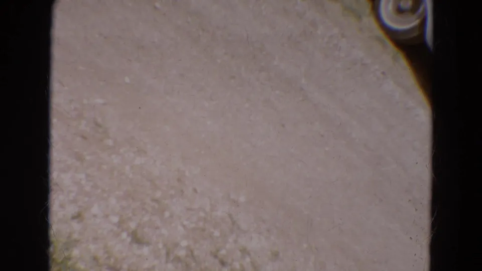 1968 Diller, Nebraska 8mm frame pointed at pale ground, bordered by dark film-gate edges and visible film wear.