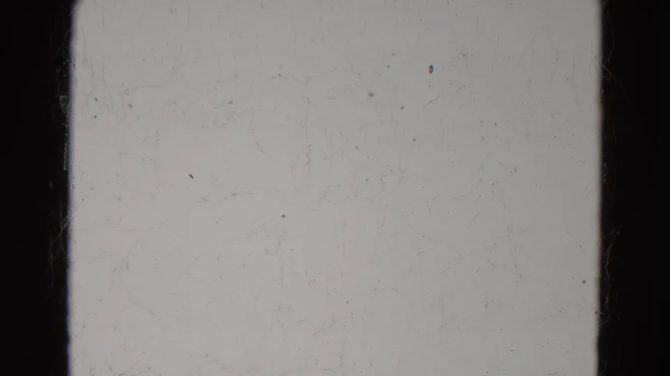 1968 8mm source frame from Diller, Nebraska showing blank pale film, black vertical bars, dust specks, and surface scratches.