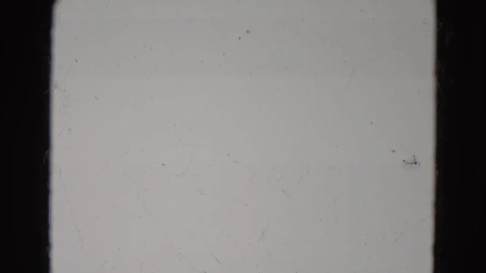 1968 Diller, Nebraska 8mm frame showing pale blank film, a black vertical bar, faint horizontal banding, dust, and fine surface marks.