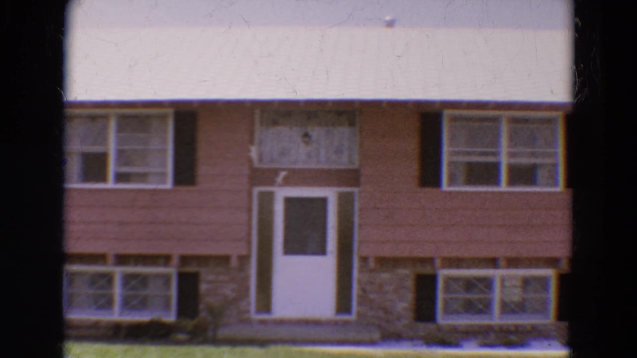 Two-story house with salmon siding, black shutters, white front door, and stone lower facade.