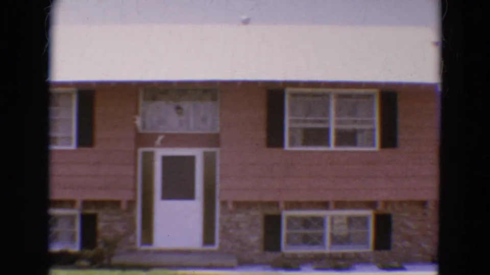 1968 Diller, Nebraska frame with the house front more centered, showing white door, paired windows, black shutters, and stone facing.
