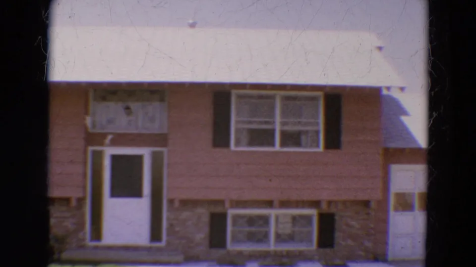 1968 Diller, Nebraska frame showing the house front from a slightly shifted angle, with part of an attached garage visible at right.