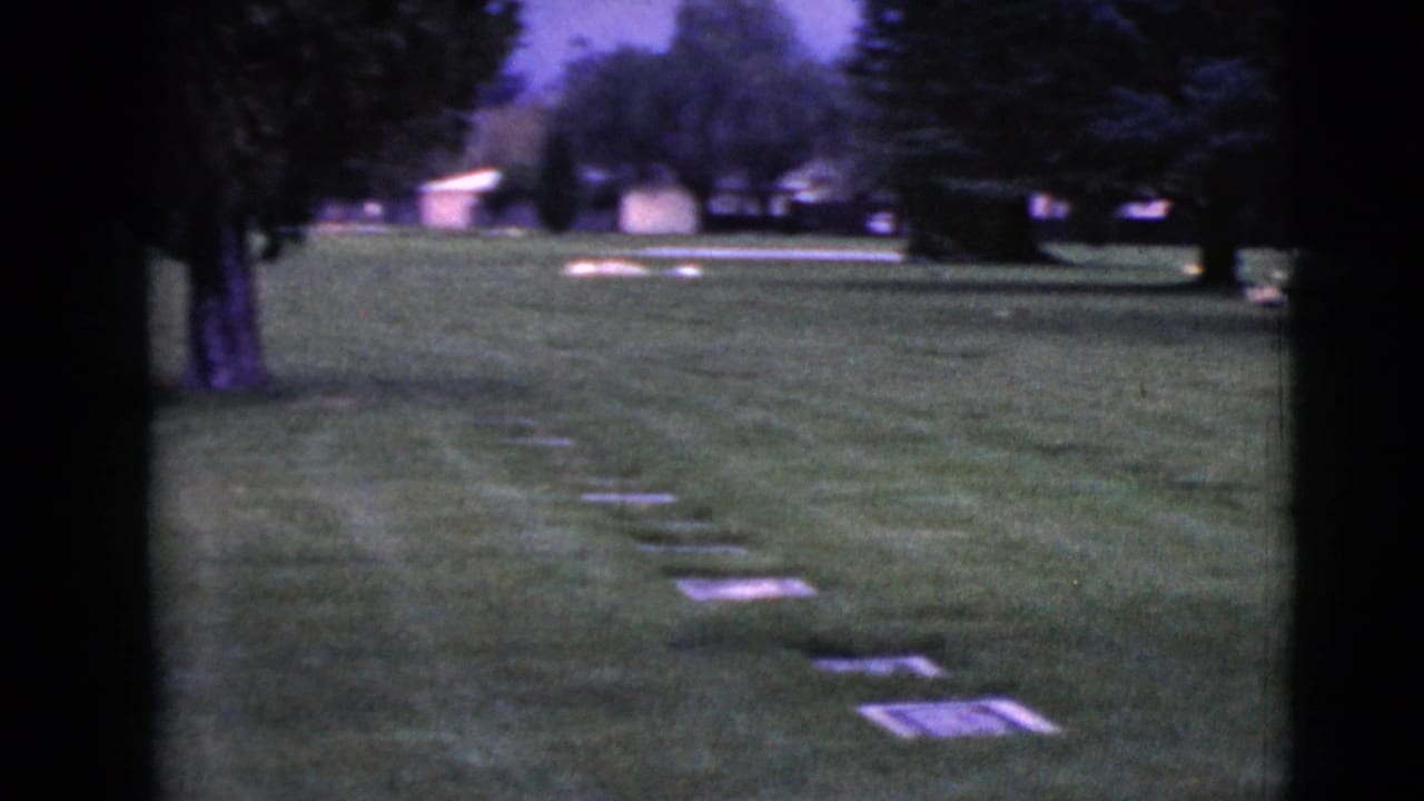 Clarksdale, Arizona cemetery grounds in 1968, with flat markers visible in the grass beneath mature trees.