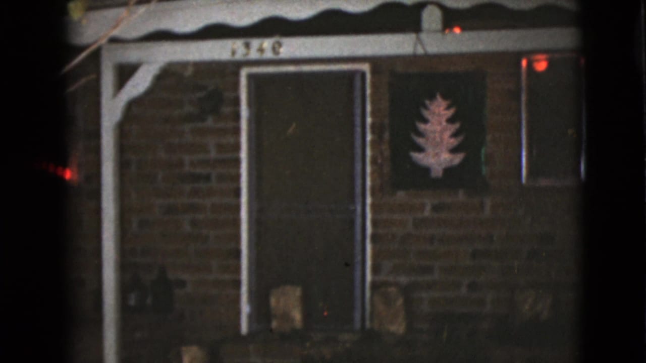 1968 Clarksdale, Arizona frame of the same brick home facade, centered on the door, porch number, and holiday tree decoration.