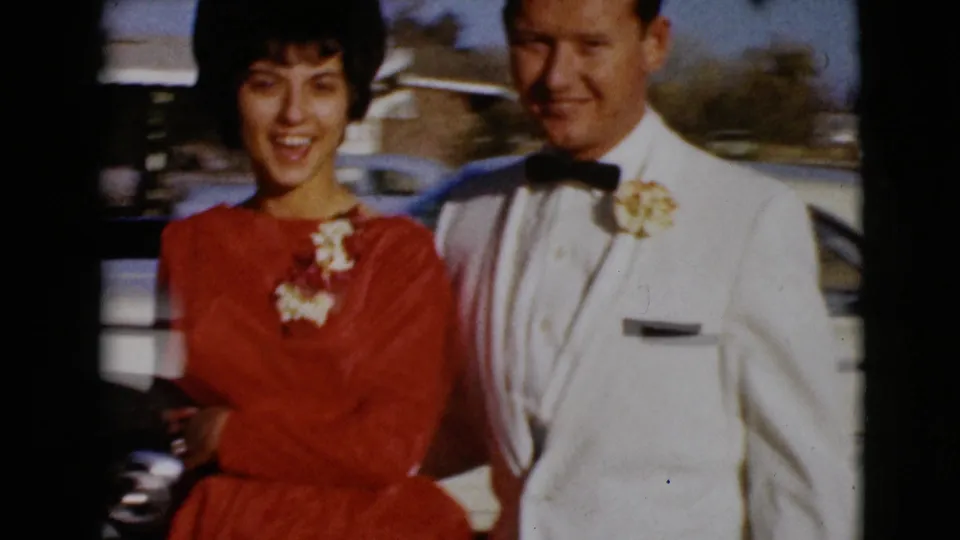 A closer 8mm frame shows the couple smiling in wedding attire, with her red dress and his white jacket prominent.