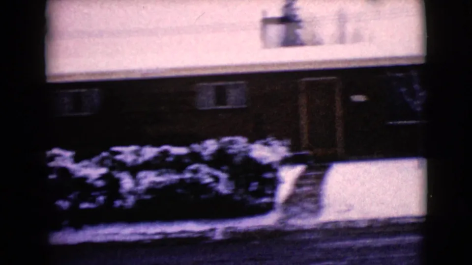 Snowy 1968 residential exterior in Clarksdale, Arizona, with a low house, front walk, shrubs, and winter street foreground.