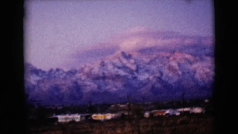 The pan continues across the Clarksdale, Arizona landscape, with soft 8mm focus on snowy peaks and a small town foreground.