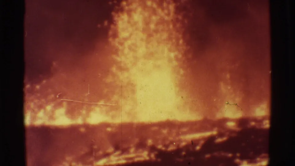 1971 Mauna Ulu 8mm footage showing a bright lava plume and orange glow across a dark volcanic landscape.