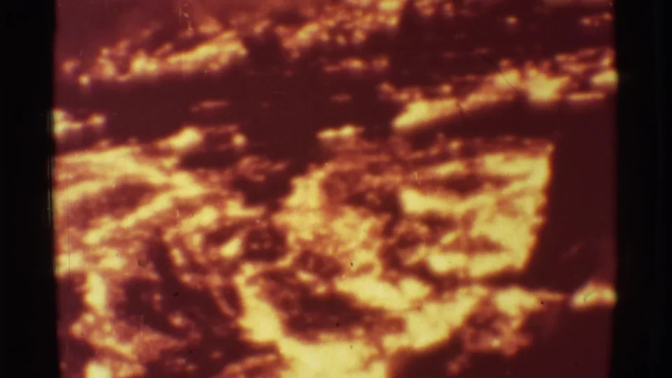 1971 Mauna Ulu lava close-up showing bright flowing areas against darker cooling crust on 8mm film.