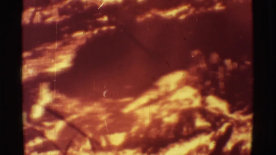 1971 Mauna Ulu, Hawaii 8mm frame showing glowing lava, dark crust, and soft film grain with scratches.