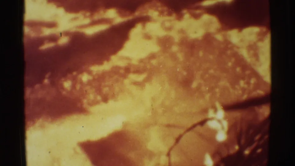 1971 Mauna Ulu, Hawaii 8mm frame with bright lava, dark crust, smoky haze, scratches, and warm color shift.