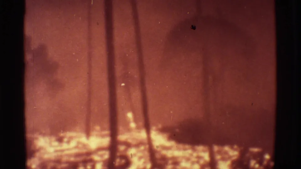 1971 Mauna Ulu 8mm frame showing dark tree trunks over bright lava glow, smoke or heat haze, and red-orange exposure.