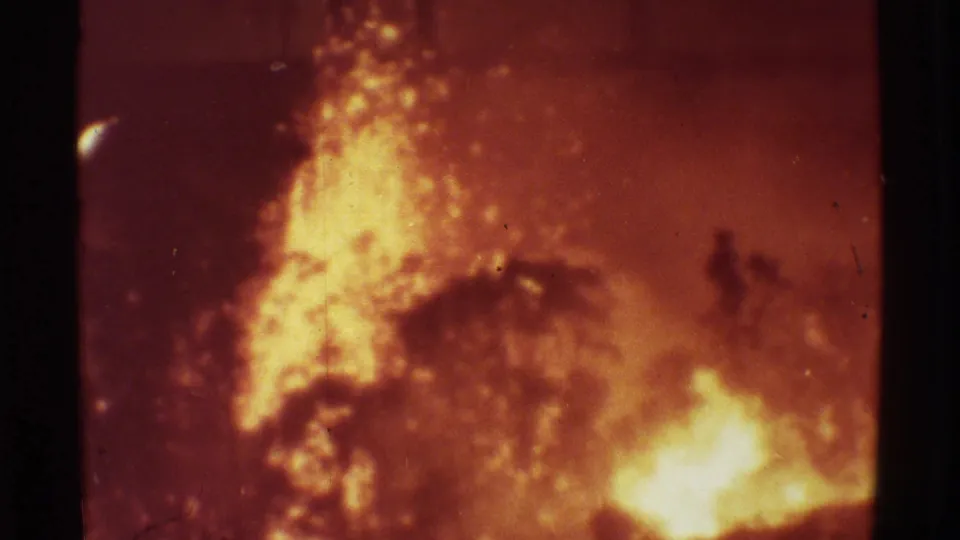 1971 Mauna Ulu 8mm frame showing bright bubbling lava and smoke, with dark vegetation shapes at the edges.