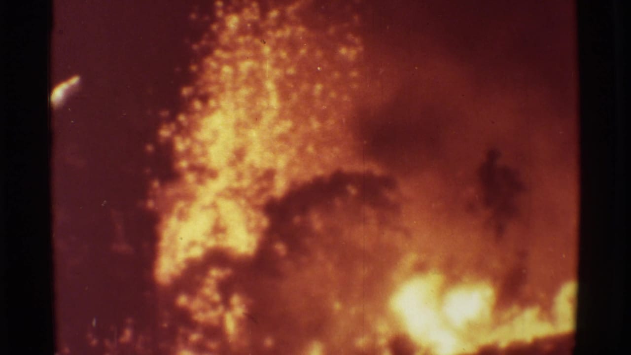 Glowing lava bursts upward beside dark smoke and shadowed tree shapes.