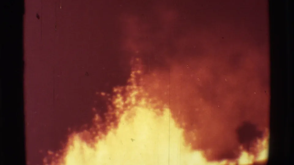 1971 Mauna Ulu footage showing yellow molten lava spraying beneath red smoky haze on an 8mm frame.