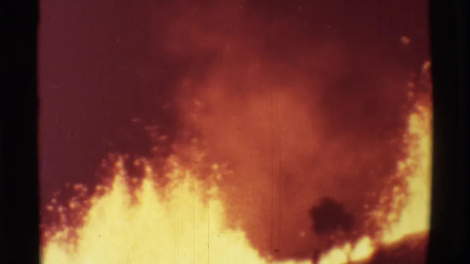 1971 Hawaii volcano footage showing a glowing lava surface and red smoky plume within a grainy 8mm frame.