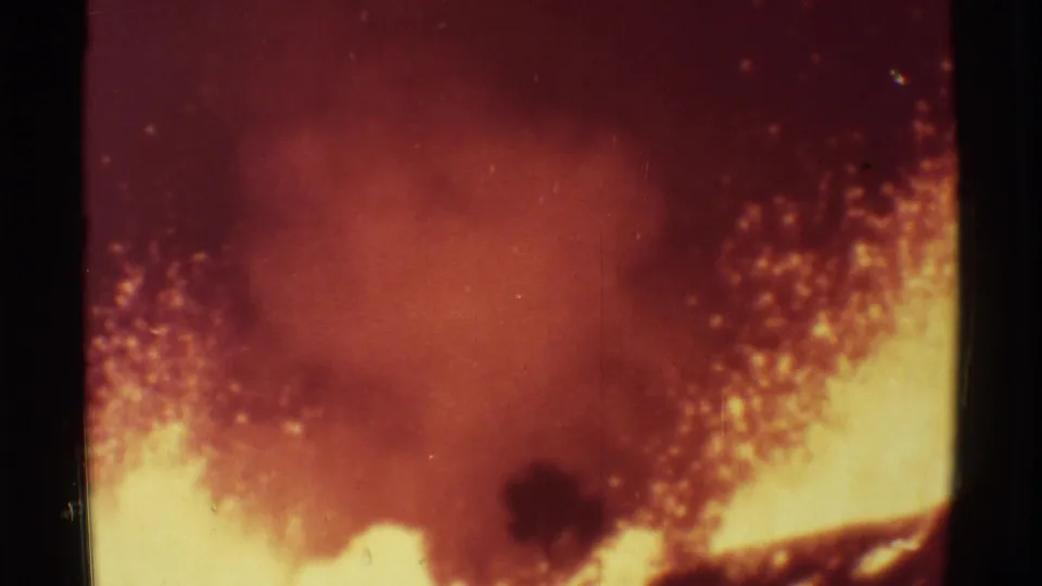 1971 Mauna Ulu 8mm frame showing molten lava spray glowing yellow-orange beneath smoky volcanic haze.