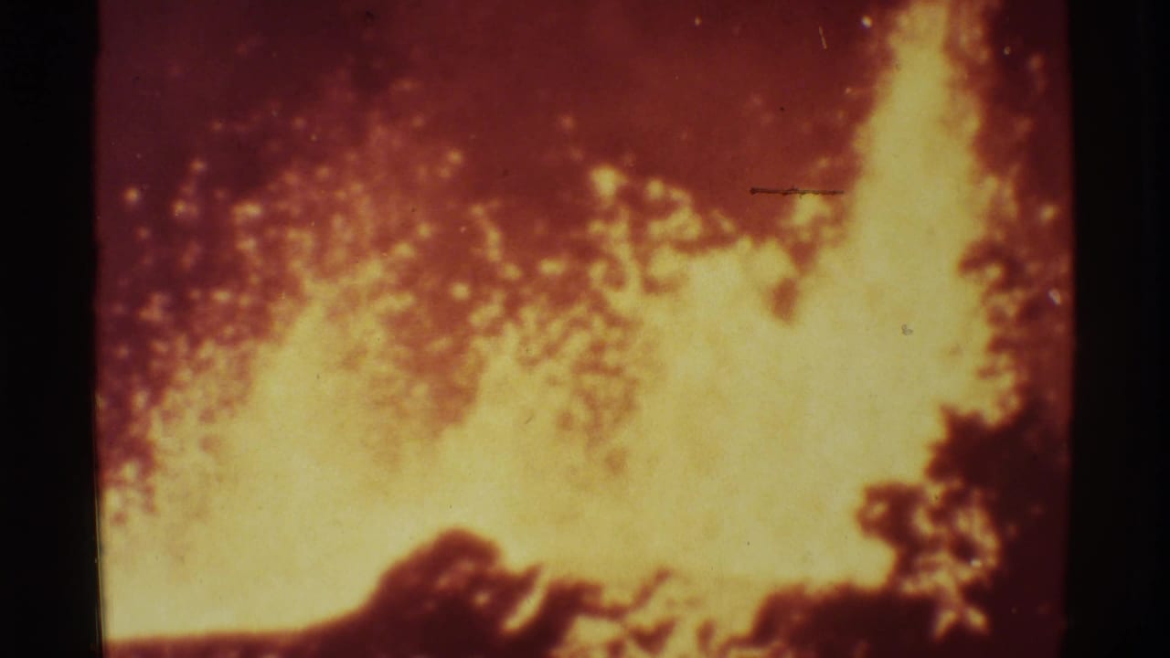 Large yellow lava flare rises against a red volcanic background.