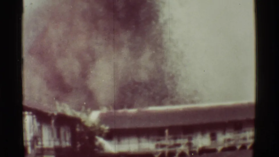 1971 Mauna Ulu home-movie frame showing a softer, diffuse volcanic plume behind a low structure, with visible grain and scratches.
