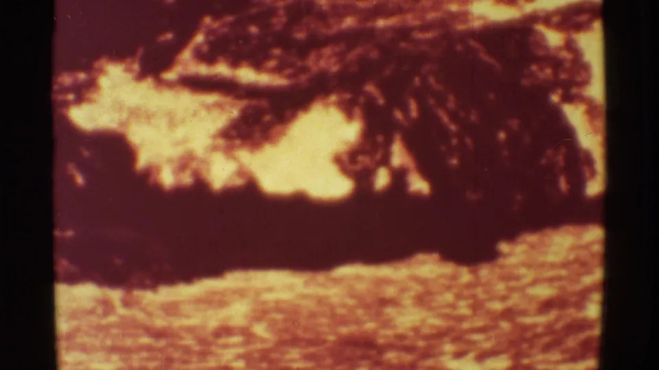 1971 Mauna Ulu, Hawaii 8mm frame showing bright molten lava beneath dark crusted rock, with rough volcanic surface filling the foreground.