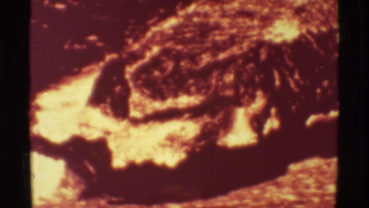 1971 Mauna Ulu 8mm frame showing bright molten lava beside darker crusted volcanic flow.
