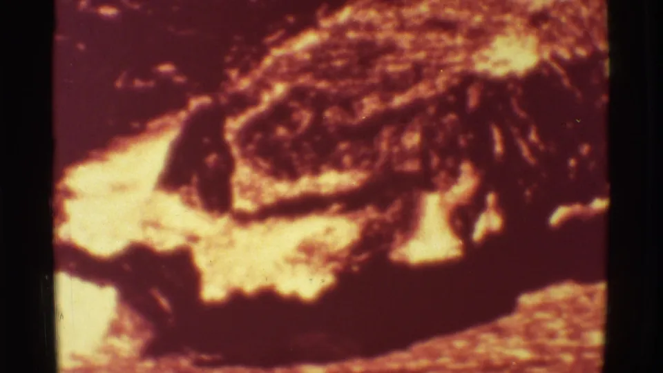 1971 Mauna Ulu 8mm frame showing bright molten lava beside darker crusted volcanic flow.