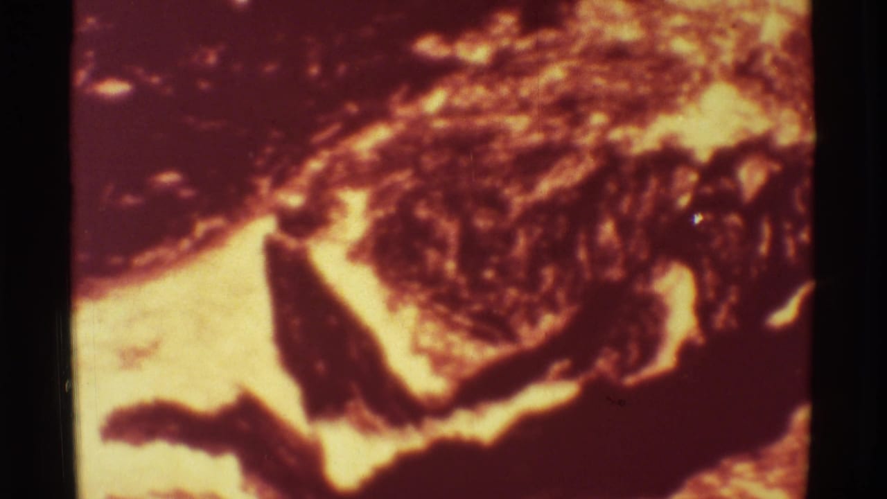 Bright lava flow curves through a dark crusted volcanic surface.