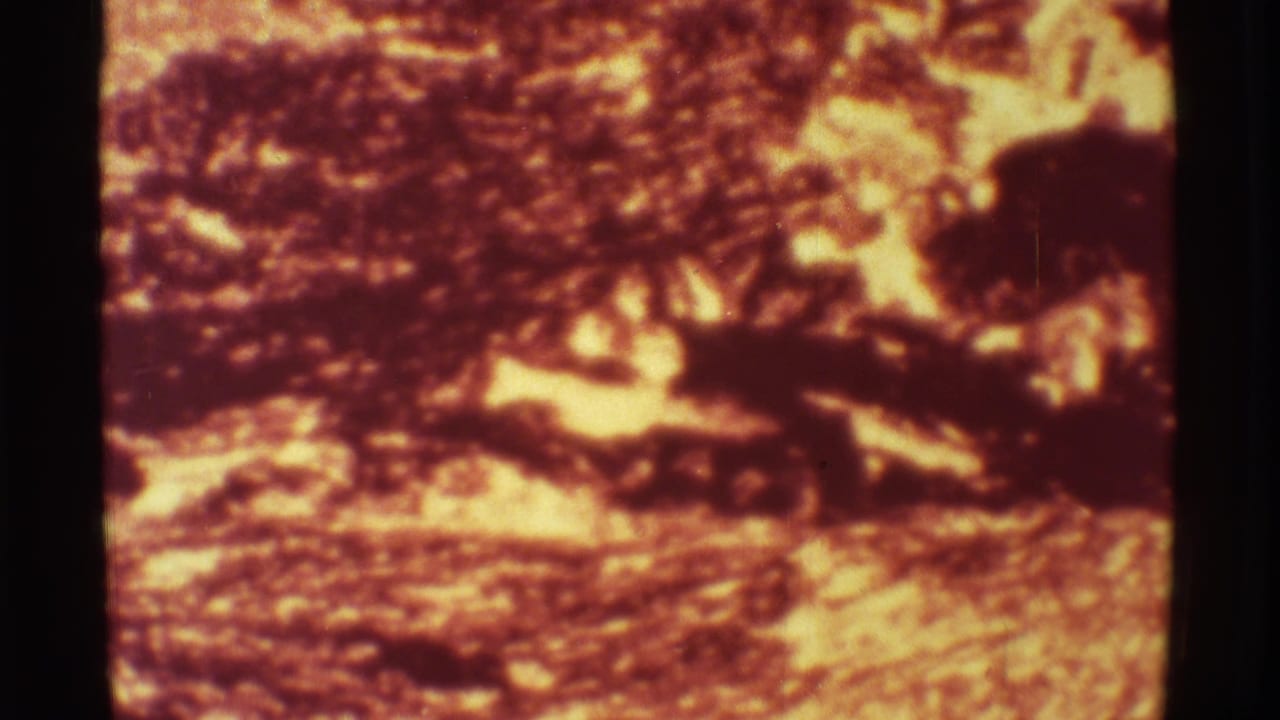 1971 Hawaii volcano footage showing bright lava flow and dark crust in a soft, grainy 8mm scan.